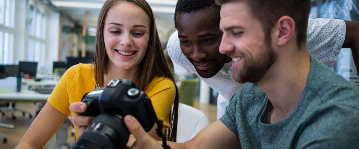 Graphic designer showing picture to his colleagues in camera at office